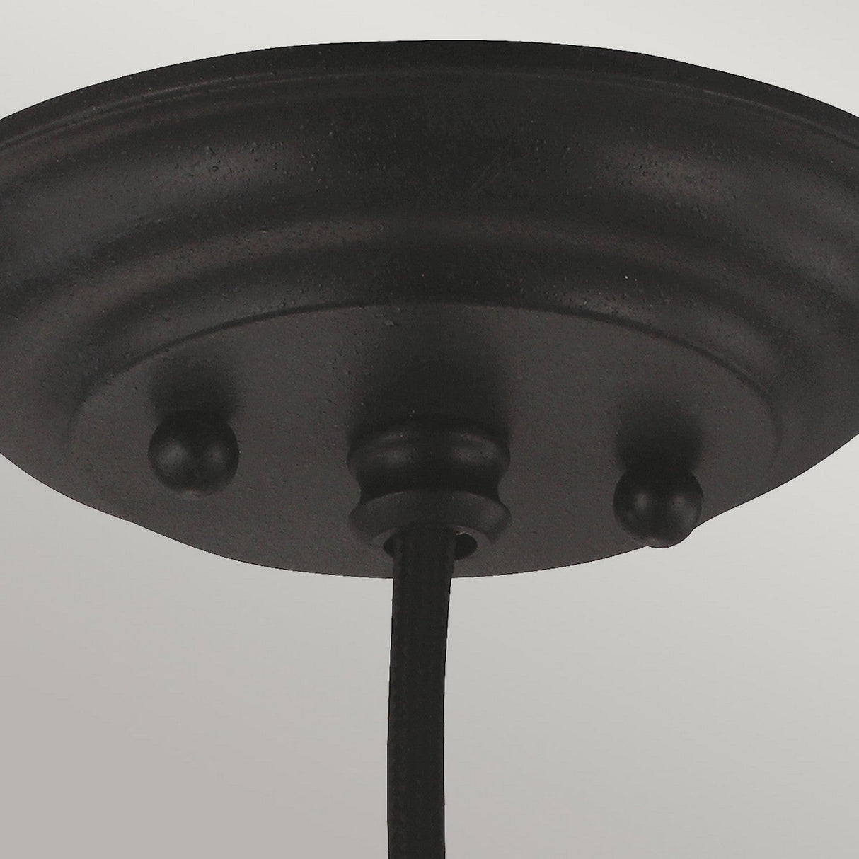 A close-up of the Matrimonio 1 Light Pendant in Driftwood/Dark Weathered Zinc showcases its round base and textured finish. It includes two decorative knobs and a hanging cord, set against a neutral background to create an inviting rustic lighting element.