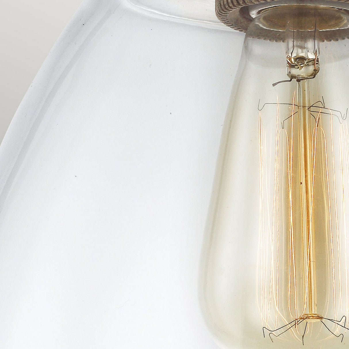 Close-up of the Matrimonio 1 Light Pendant, showcasing its vintage-style light bulb with a visible filament and glass bulb against a dark weathered zinc socket, which highlights the intricate filament design and adds rustic lighting charm.