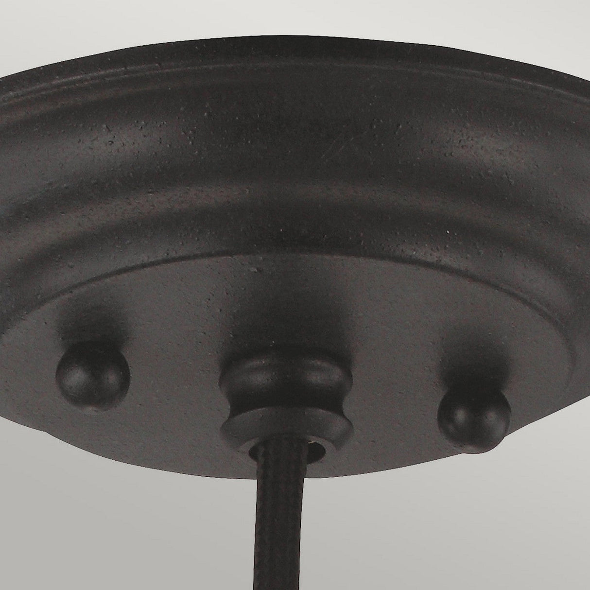 Close-up of the Matrimonio 1 Light Mini Pendant with a dark weathered zinc finish, featuring three decorative knob details and a central cord, embodying rustic lighting. The slightly textured surface complements the round shape, set against a light gray background, perfect for enhancing any space with its timeless charm.