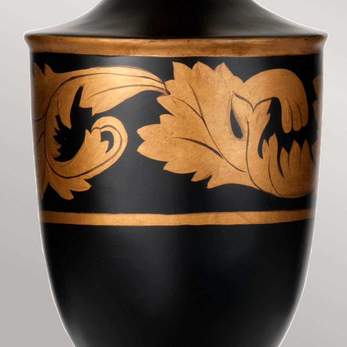 Close-up of the Narbonne Table Lamp - Black & Gold, showcasing its design with stylized leaves and floral motifs in gold on a matte black background. The elegant ornamentation evokes a classic or antique style.