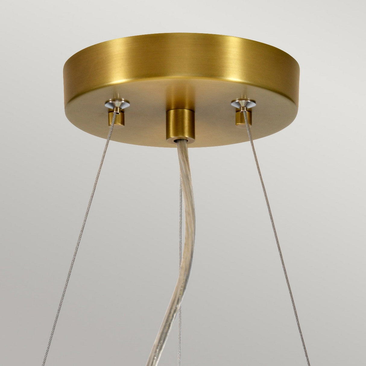 A close-up of the Pearce 14" Pendant Light in aged brass and ivory shade highlights two cables connected to a round base. The fixture hangs elegantly from the ceiling with a single power cord at its center, set against a simple, light grey background.