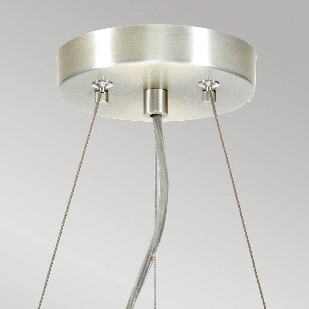 Close-up of the Pearce 14" Pendant Light in polished chrome, featuring an ivory shade. This modern fixture boasts a round base from which three cables are suspended, elegantly supporting the light below. The background is a neutral gray.