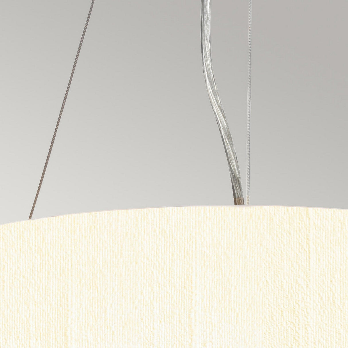 Shown is a close-up of the Pearce 14" Pendant Light, featuring an ivory-colored textured shade. This modern lighting fixture hangs by thin wires against a light gray backdrop, and includes polished chrome accents on top with visible connecting cables.
