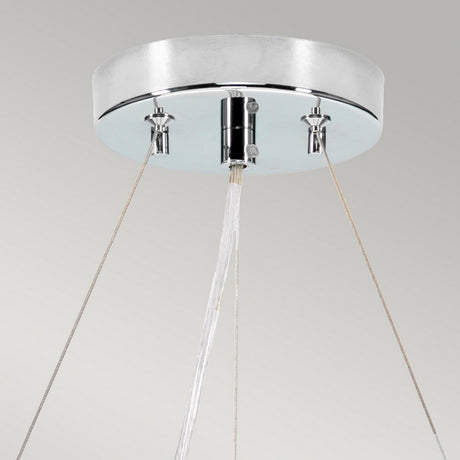 A contemporary ceiling-mounted fixture featuring a sleek, polished chrome design, reminiscent of the Pearce 18" Pendant Light. Three thin cords support a central nozzle that emits a steady stream of water, evoking the elegance of an ivory-shaded pendant light against a neutral backdrop.