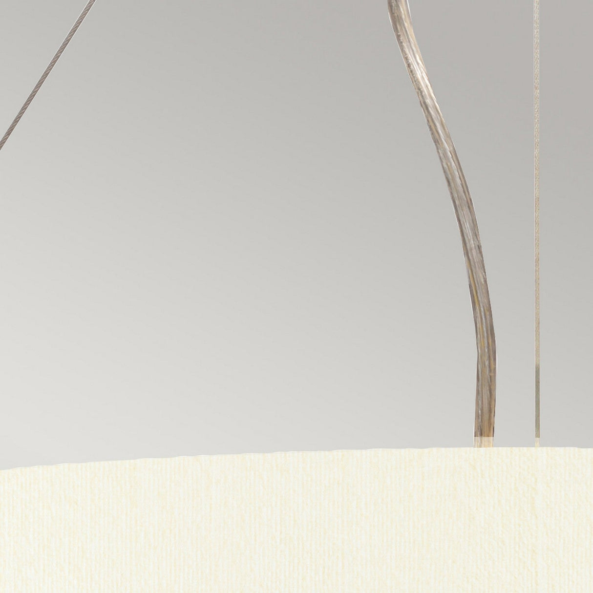 Featuring the Pearce 22" Pendant Light, this close-up showcases its sleek, curved aged brass fixture paired with a faux silk ivory shade against a neutral backdrop, highlighting the textural contrast between metal and fabric.