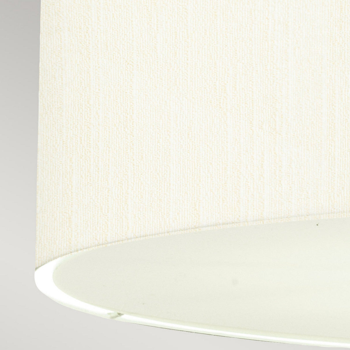 Close-up of the Pearce 22" Pendant Light featuring an ivory faux silk shade with a textured fabric surface. The underside showcases a smooth, elegant interior that beautifully complements the aged brass fixture. Set against a neutral background, this pendant light exudes understated sophistication.