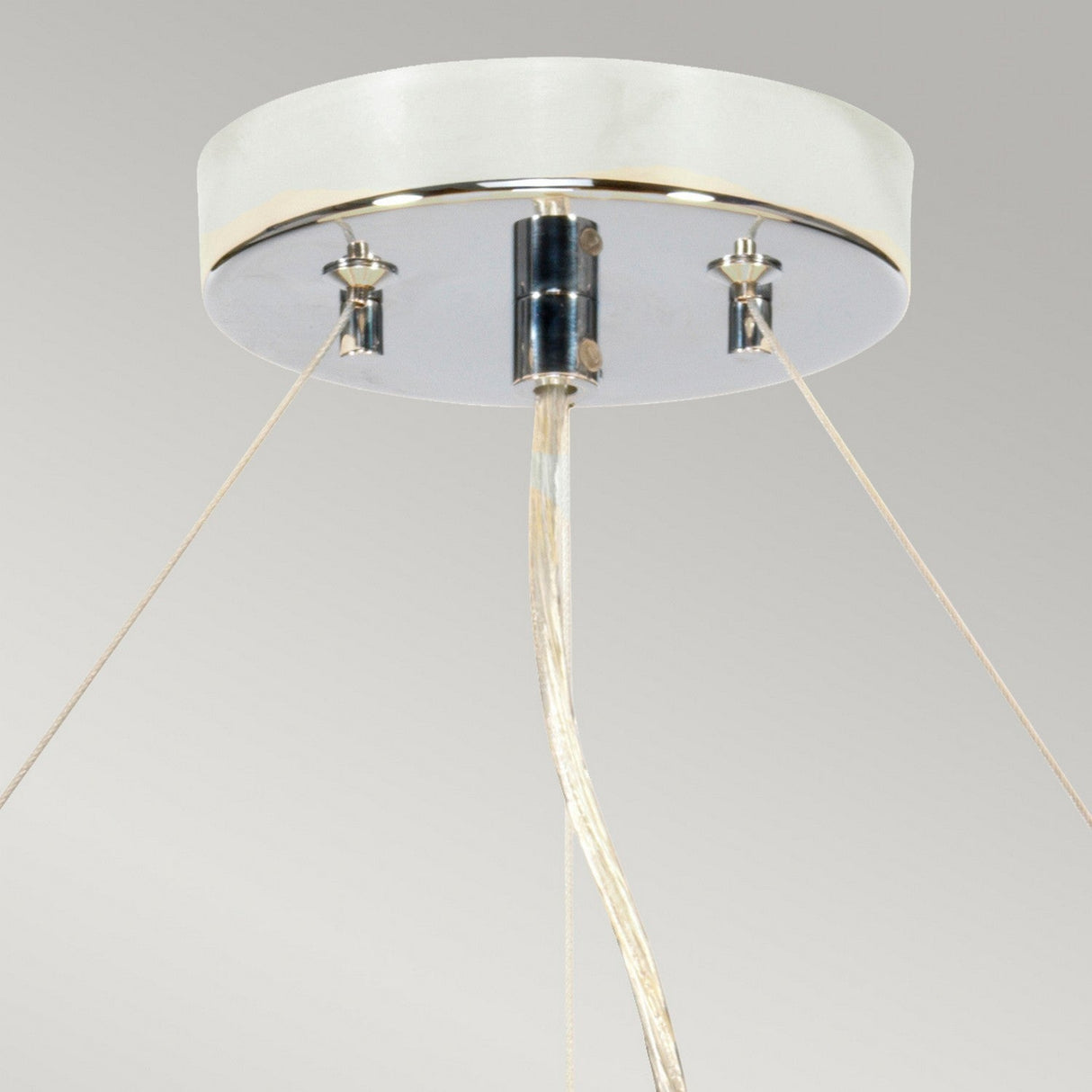 The Pearce 22" Pendant Light in polished chrome, featuring an ivory shade, showcases a close-up view with a circular white base suspended elegantly from the ceiling by three wires. These wires meet at a central metallic cylinder, offering a sleek and minimalist design that beautifully complements modern interiors against a light gray background.