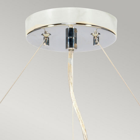 The Pearce 22" Pendant Light in polished chrome, featuring an ivory shade, showcases a close-up view with a circular white base suspended elegantly from the ceiling by three wires. These wires meet at a central metallic cylinder, offering a sleek and minimalist design that beautifully complements modern interiors against a light gray background.