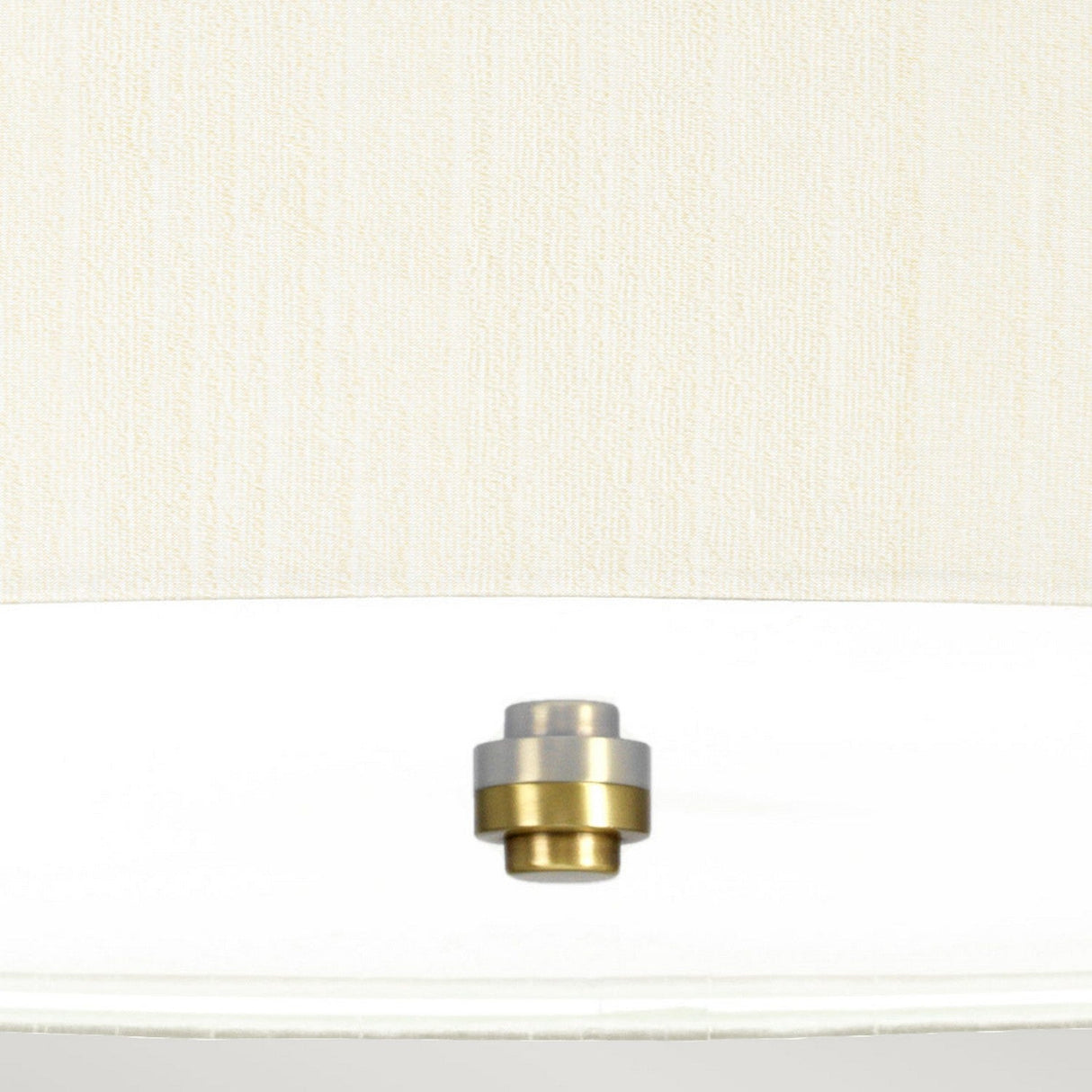 Close-up of the Pearce 26" Pendant Light exhibiting a sophisticated two-tone metallic finish reminiscent of silver and gold, akin to an aged brass. The faux silk ivory shade enhances its elegance, set against a neutral textured background, showcasing a sleek blend of design and sophistication.