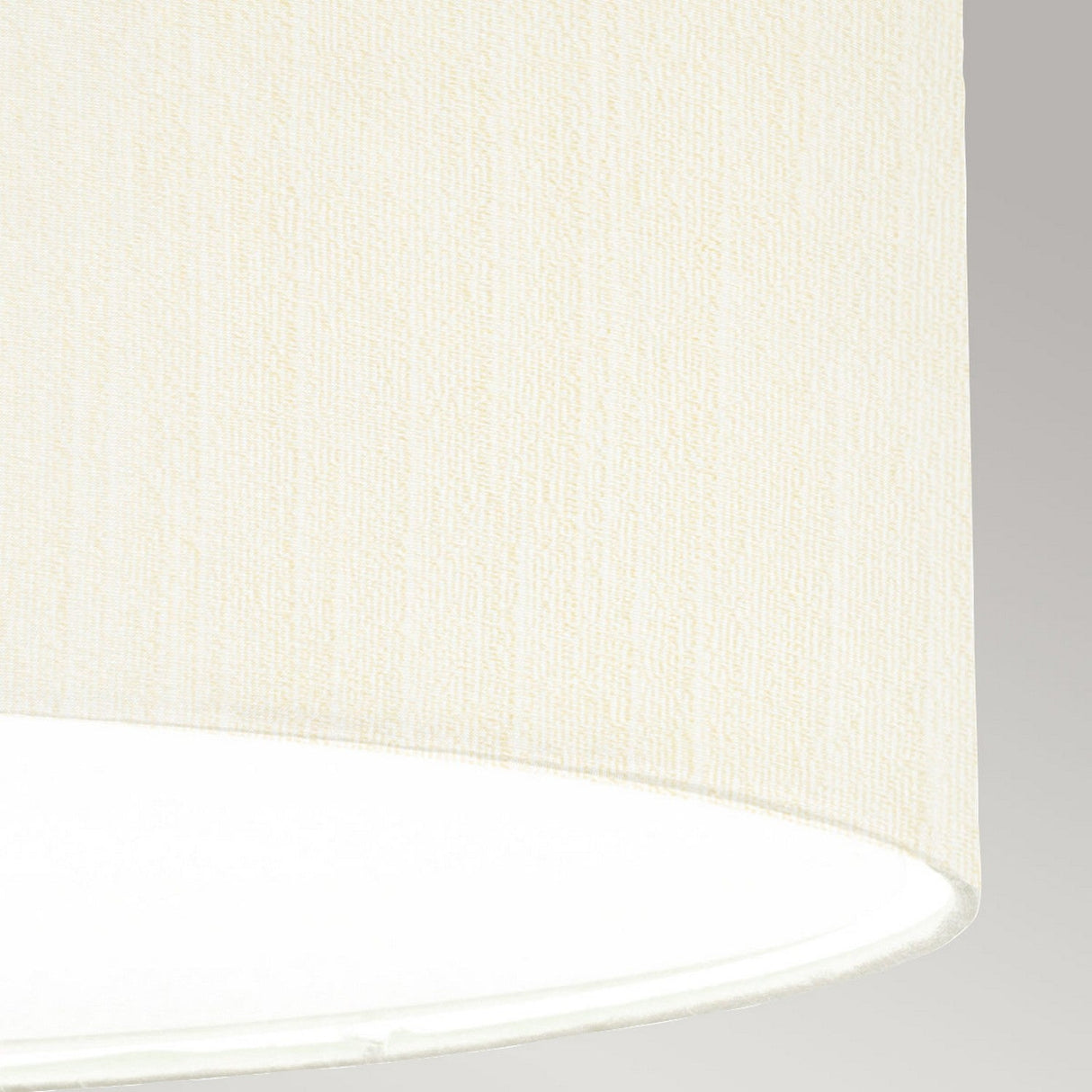 Close-up of the textured surface of the ivory shade from the Pearce 26" Pendant Light in aged brass. The bottom section is set against a plain gray background, exuding an elegant charm.