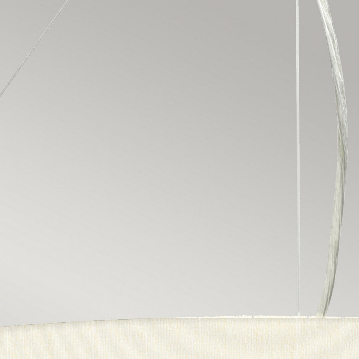Close-up of the Pearce 26" Pendant Light featuring an ivory fabric-covered shade. Thin wires hold the fixture against a neutral background, enhancing its minimalist aesthetic. The bottom edge of the shade is visible, showcasing a soft, textured appearance with polished chrome accents.