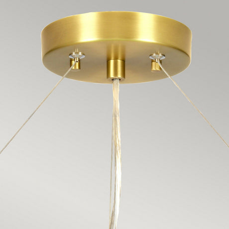 A close-up of the Pearce 34" Pendant Light in aged brass, featuring an ivory shade with wires extending from the base, set against a plain light gray background.