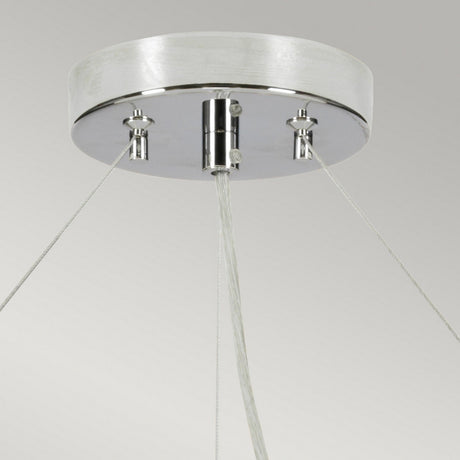A close-up of the Pearce 34" Pendant Light - Polished Chrome Ivory Shade highlights its sleek design, featuring a polished chrome finish with a round, metallic base. Three wires extend symmetrically downward, making it an ideal fit for modern interiors. This fixture is mounted on a smooth, light-colored ceiling.