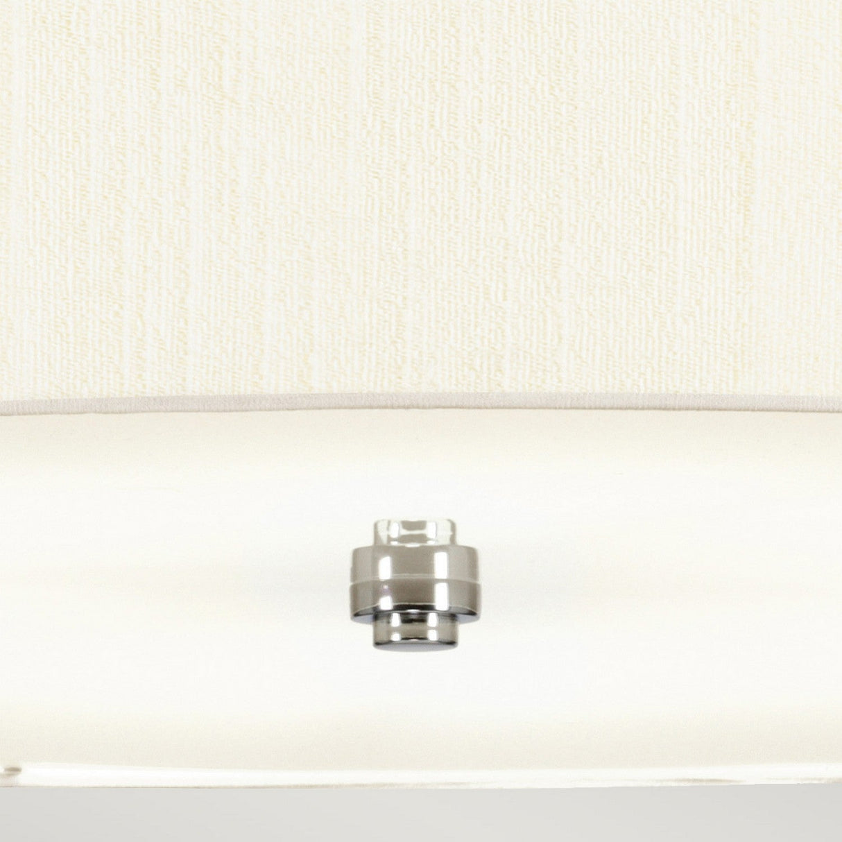 A detailed view of the Pearce 34" Pendant Light with its polished chrome socket set against a cream-colored textured wall. The unlit socket, mirroring contemporary interior designs, is centered and presents a sleek, minimalistic look similar to that of a pendant light configuration.