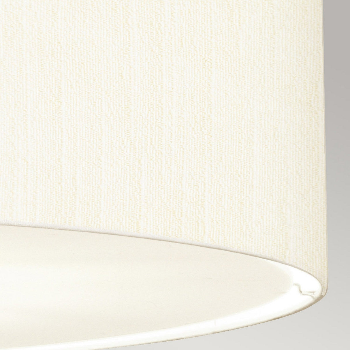 Close-up of the Pearce 34" Pendant Light featuring an ivory fabric lampshade with a subtle textured pattern, ideal for modern interiors. The edge of the pendant light showcases the polished chrome accents that enhance its sleek surface and gentle hue.