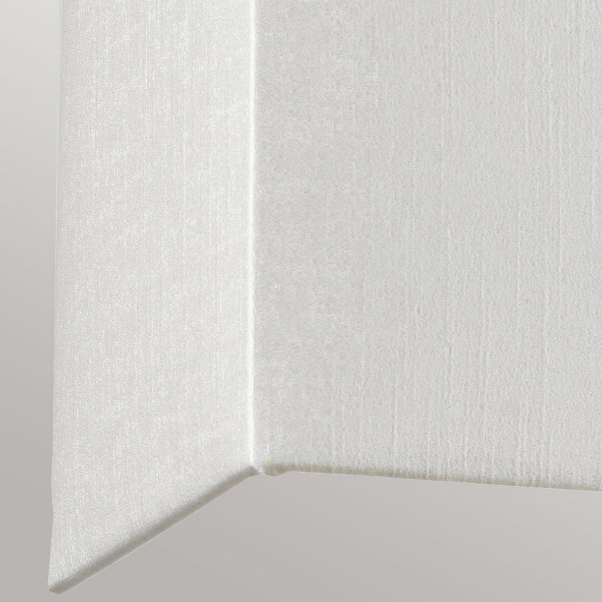 Close-up of a Riley Large Rectangular Wall Light in aged brass against a light gray background, showcasing its sharp angled corner that gives off a geometric appearance.