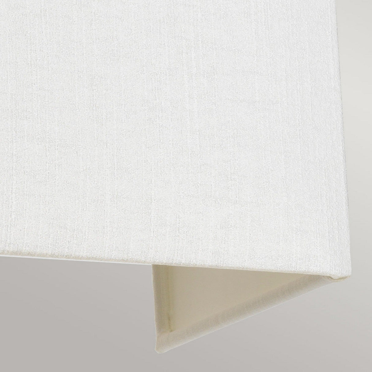 Close-up of the Riley Large Rectangular Wall Light in polished chrome featuring a white fabric lampshade with a textured surface and a triangular shape, set against a soft gray background—ideal for enhancing contemporary design lighting schemes.