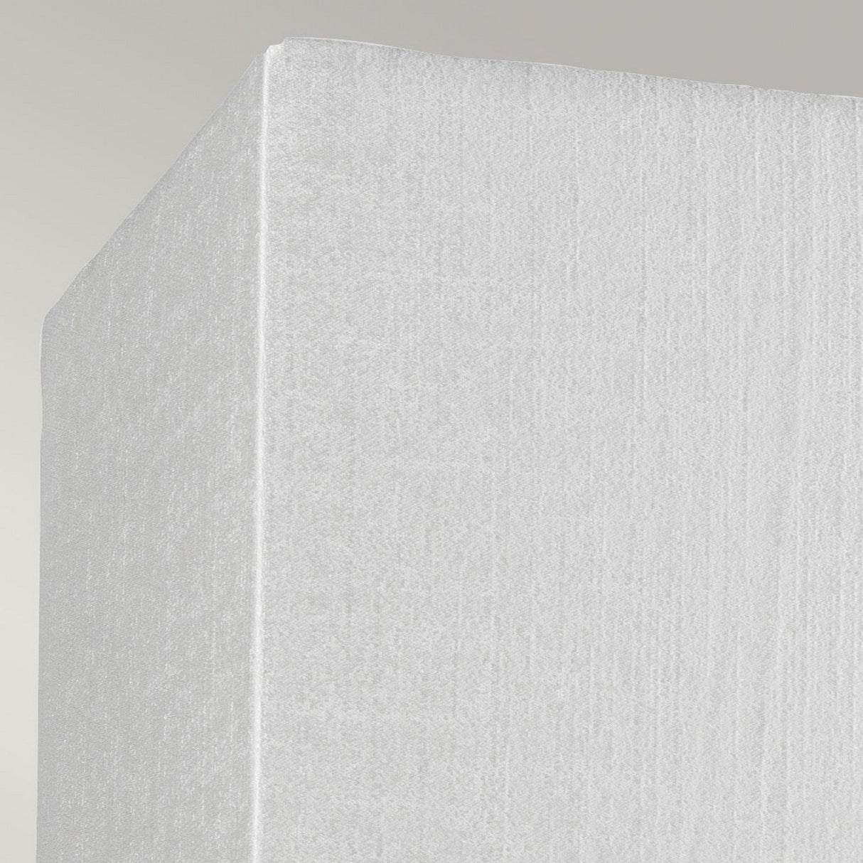 A close-up of a corner of the Riley Medium Rectangular Wall Light in polished chrome, illuminated softly against a neutral gray background.