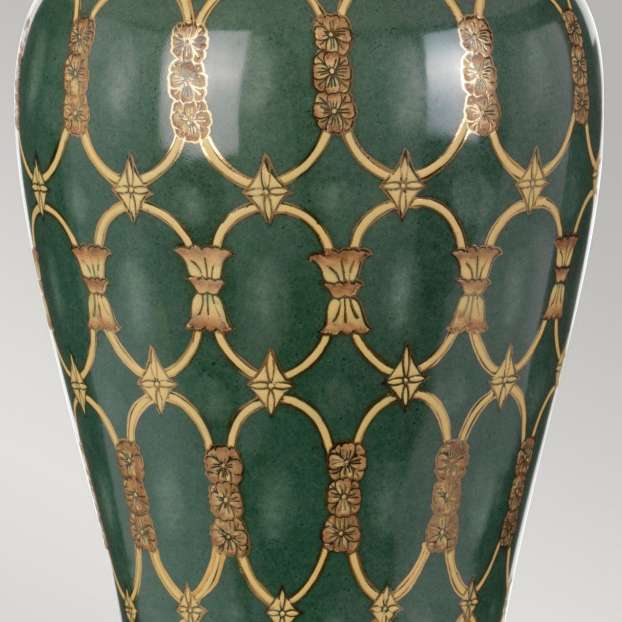 A vase featuring a green base with an intricate gold floral design, capturing the essence of oriental artistry. The motif includes interconnected arches and ornate flowers, exuding elegance and luxury similar to the ambient glow of the Sashi Table Lamp With Tall Empire Shade - Green With Gold & Brown.