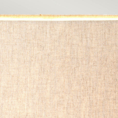 Close-up of the Spirit Table Lamp With Oval Shade in bronze patina, showcasing its fine, textured fabric. When illuminated from within, it emits a warm glow that enhances the overall ambiance. The light background complements its warmth, making it ideal for equestrian enthusiasts seeking a cozy atmosphere.