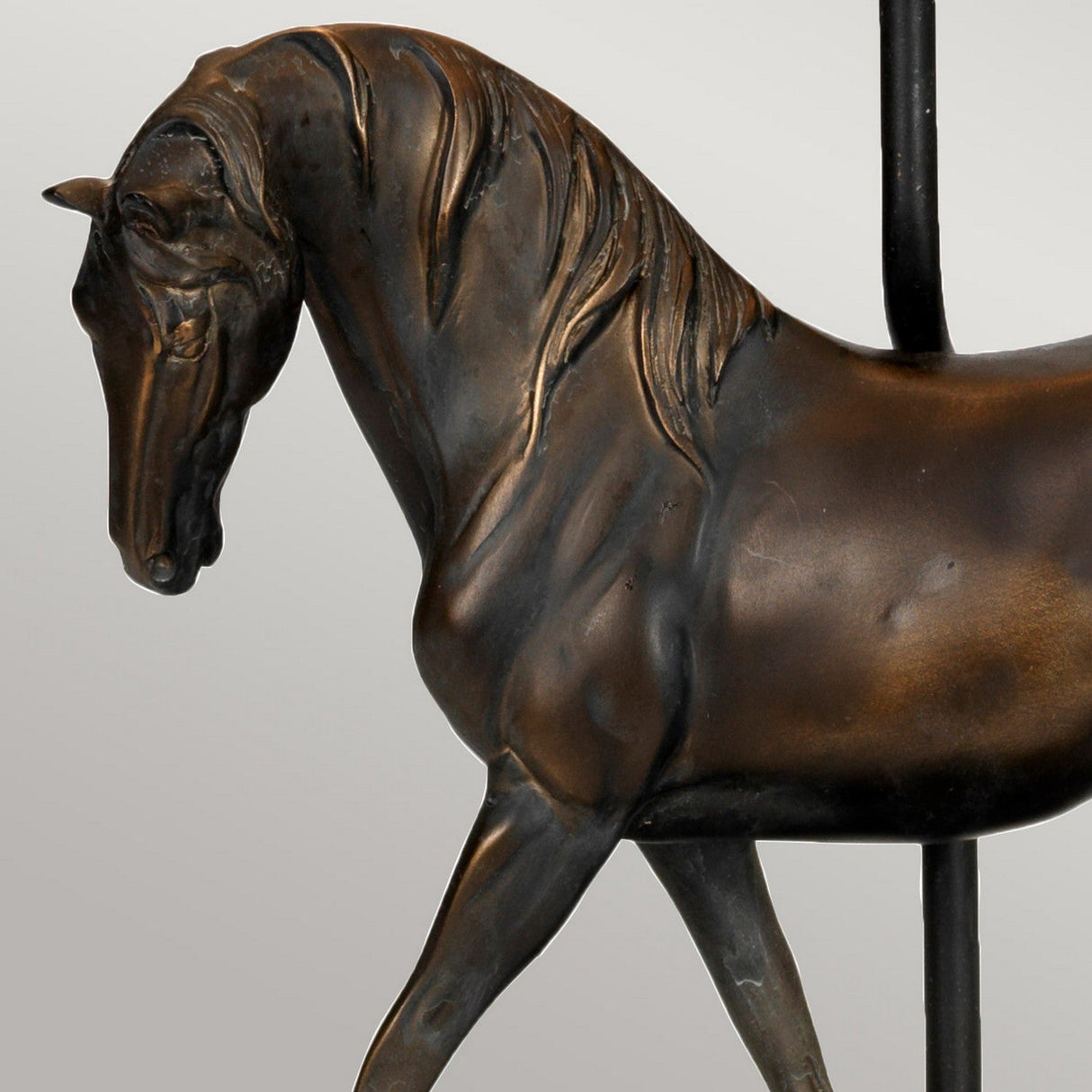 The Spirit Table Lamp With Oval Shade - Bronze Patina features a horse motif crafted with intricate details, exhibiting a rich bronze patina against a minimalist design. The lamp captures the grace of equestrian elegance, with the horse depicted in a poised stance and head gently bowed.