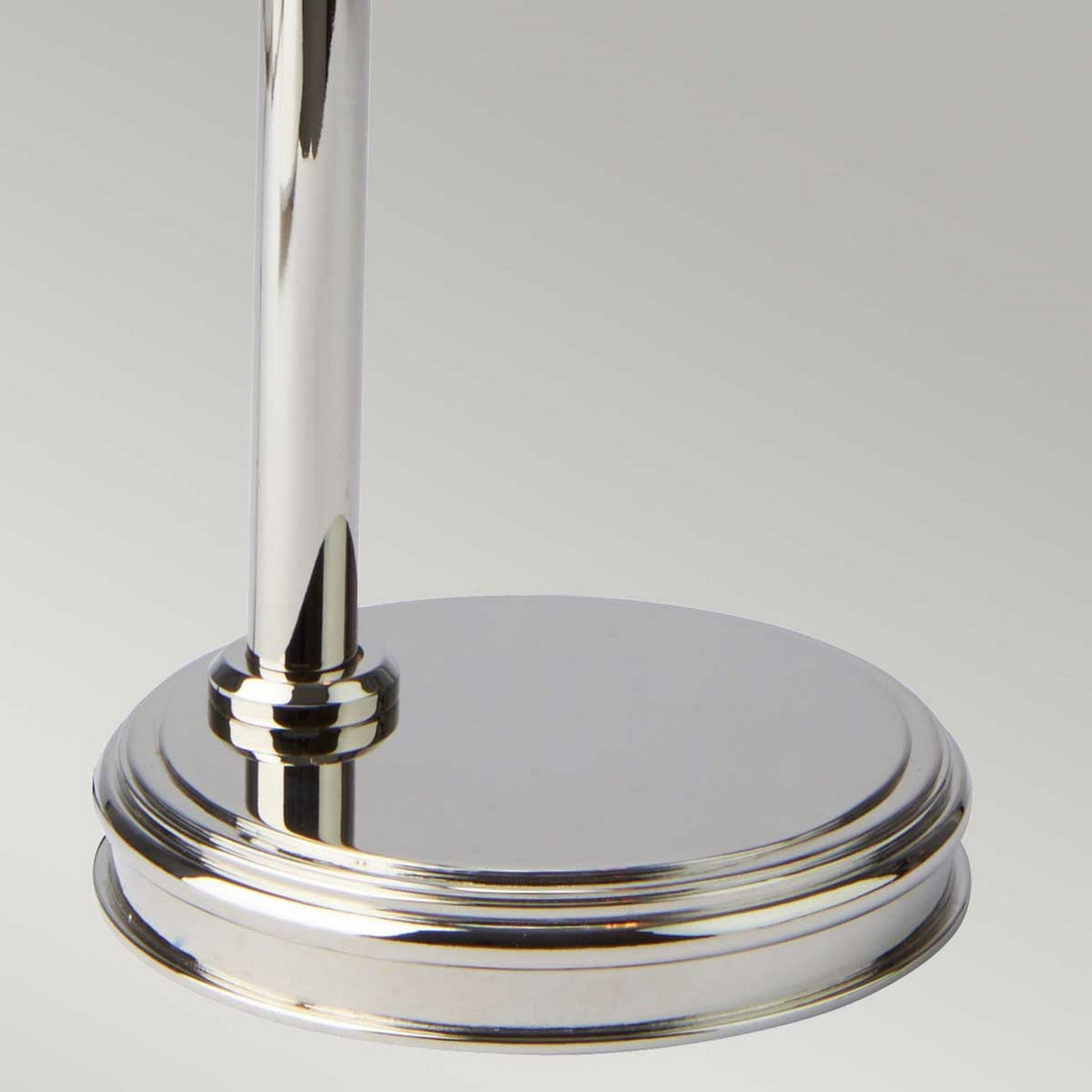 Close-up of the Douille Table Lamp - Polished Nickel base and stem, showcasing its smooth, reflective surface. The background features a subtle gradient of light gray tones, perfect for highlighting vintage-style LED filament bulbs.