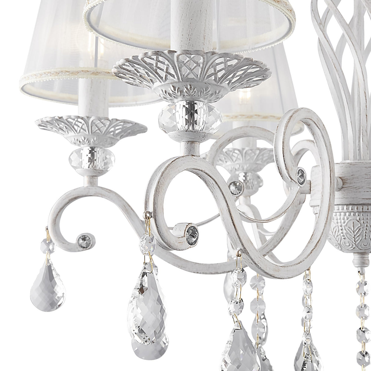 The Grace 6 Light Chandelier - White showcases elegant lighting with intricate metalwork and candle-style bulbs, adorned with crystal pendants for a vintage allure.