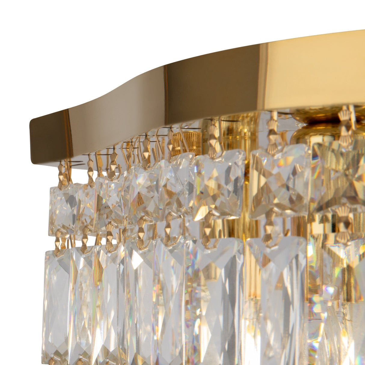 A close-up of the Dune 6 Light Flush in gold and crystal, showcasing its rectangular prisms dangling from a sleek gold fixture. The crystals reflect light, creating a sparkling effect on a plain white background.