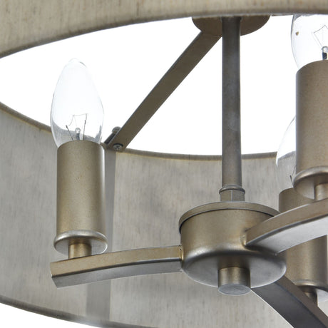 Close-up of the Venera 3 Light Chandelier - Brass, showcasing its circular frame and candle-shaped bulbs. The chandeliers brushed metal arms emphasize the intricate details of a bulb and the elegant central hub.
