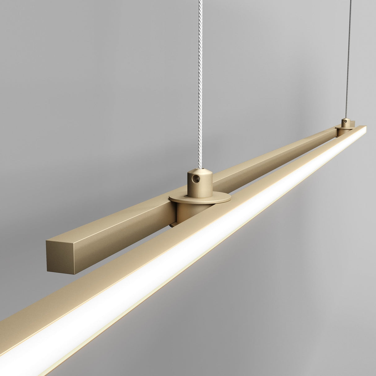 The Halo Dimmable LED Extra Long Linear Suspension Light 4000K in Brass features a modern, elongated design with dimmable functionality and slim cables, set against a neutral gray background.