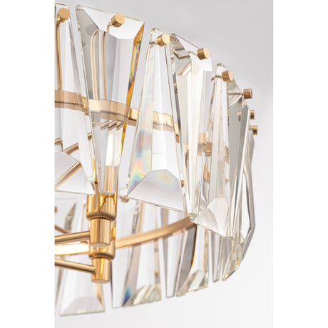 The Puntes 6 Light Chandelier - Gold is a luxurious fixture with triangular prisms on a gold metal frame. The crystals reflect light, creating a colorful spectrum, while its elegant and contemporary design emphasizes sophistication.