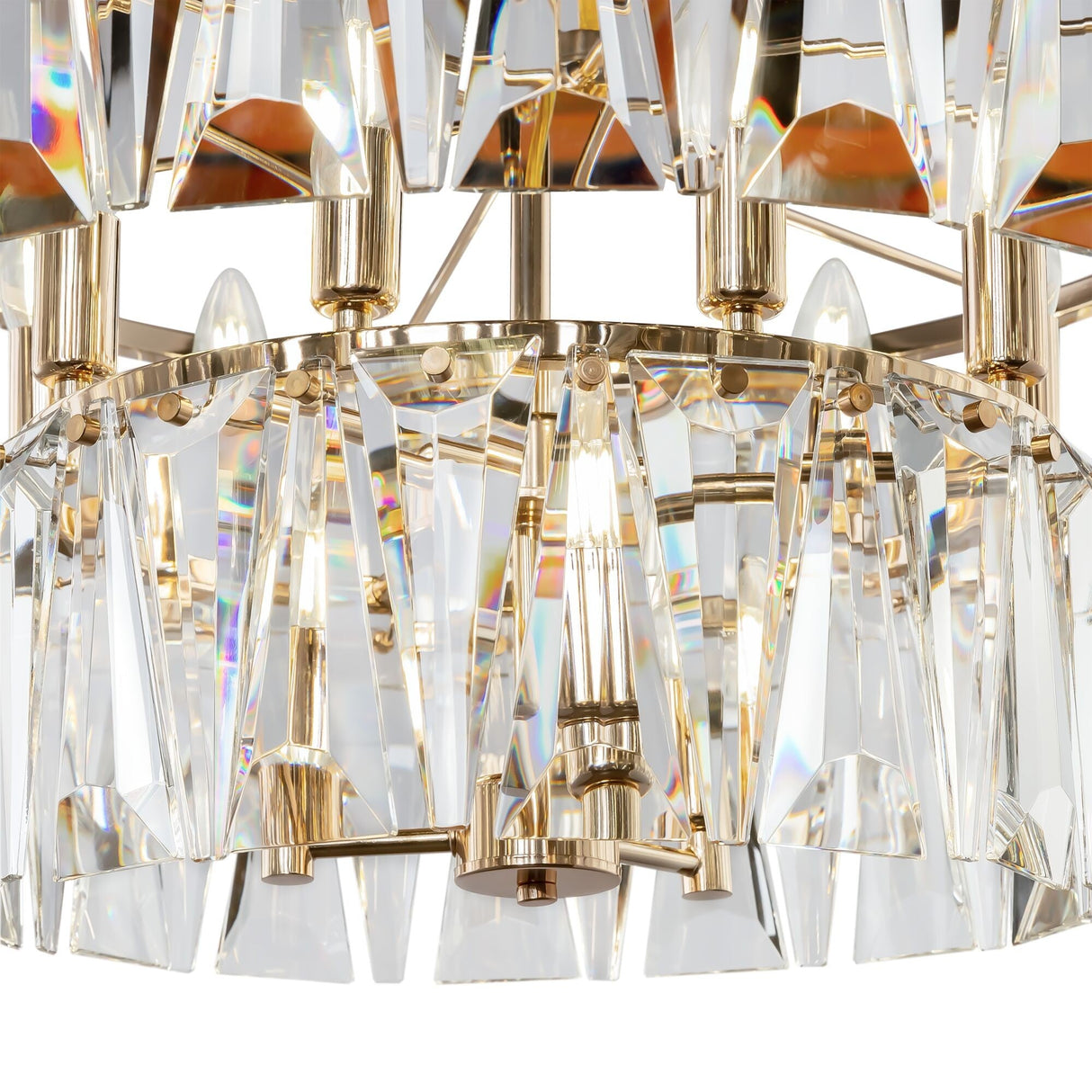 A close-up of the Puntes 12 Light Chandelier - Gold reveals elegant triangular, faceted glass crystals reflecting light. This luxury fixture has a metallic frame, adding a sparkling and opulent touch.