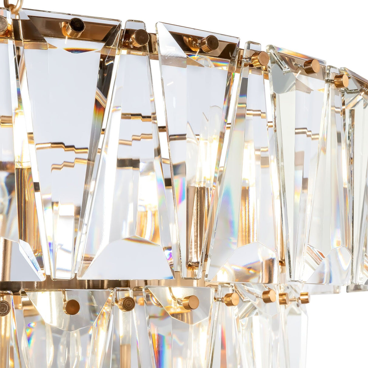 Close-up of the Puntes 18 Light Chandelier - Gold, showcasing a three-tier design with multiple triangular prisms mounted on a gold frame. Light shines through, creating colorful reflections.