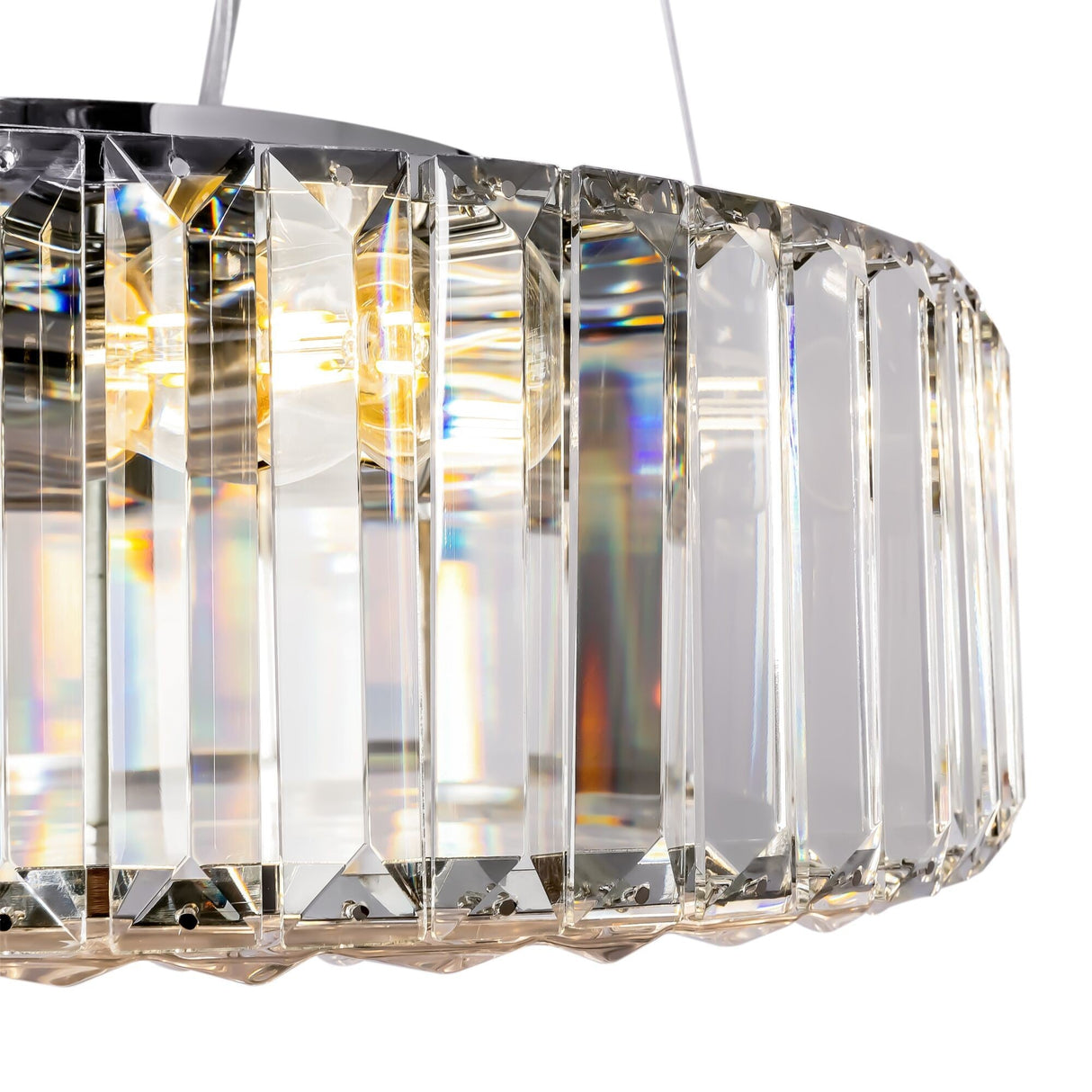 The Recinto 6 Light Chandelier - Chrome showcases faceted crystal plates in a circular design that reflect light for a bright, elegant display. Its chrome frame offers a sleek look, while it emits a warm inner glow.