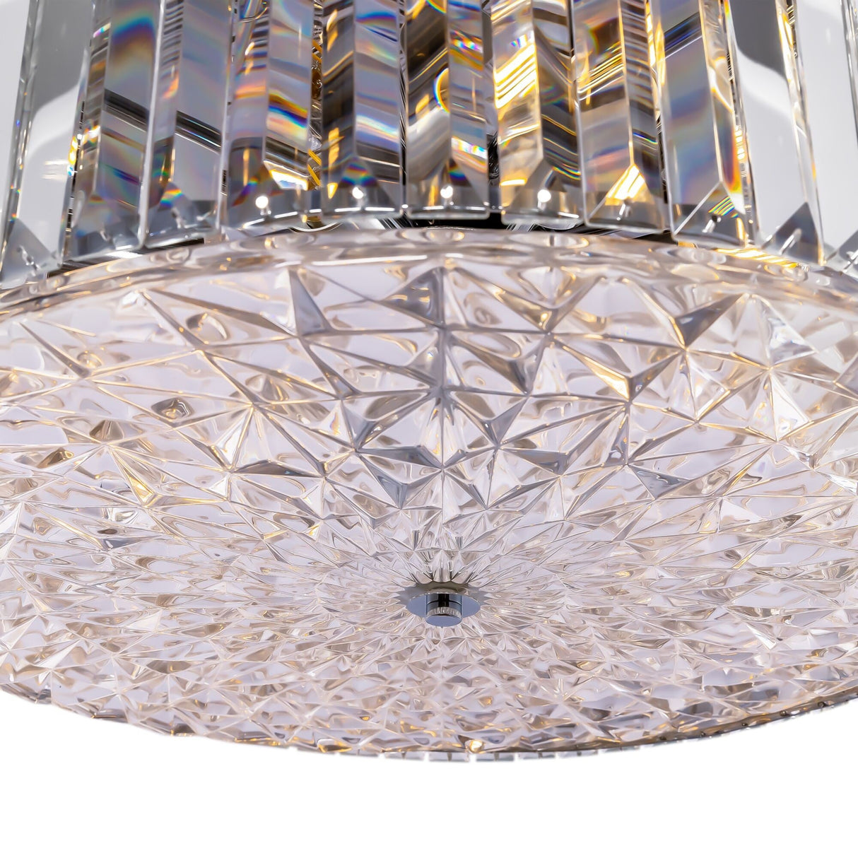 Close-up of the Recinto 8 Light Chandelier - Chrome, showcasing its geometric crystal pattern and chrome accents. The crystal plates refract light into rainbow hues, featuring a circular shape with intricate texture and a shiny finish.