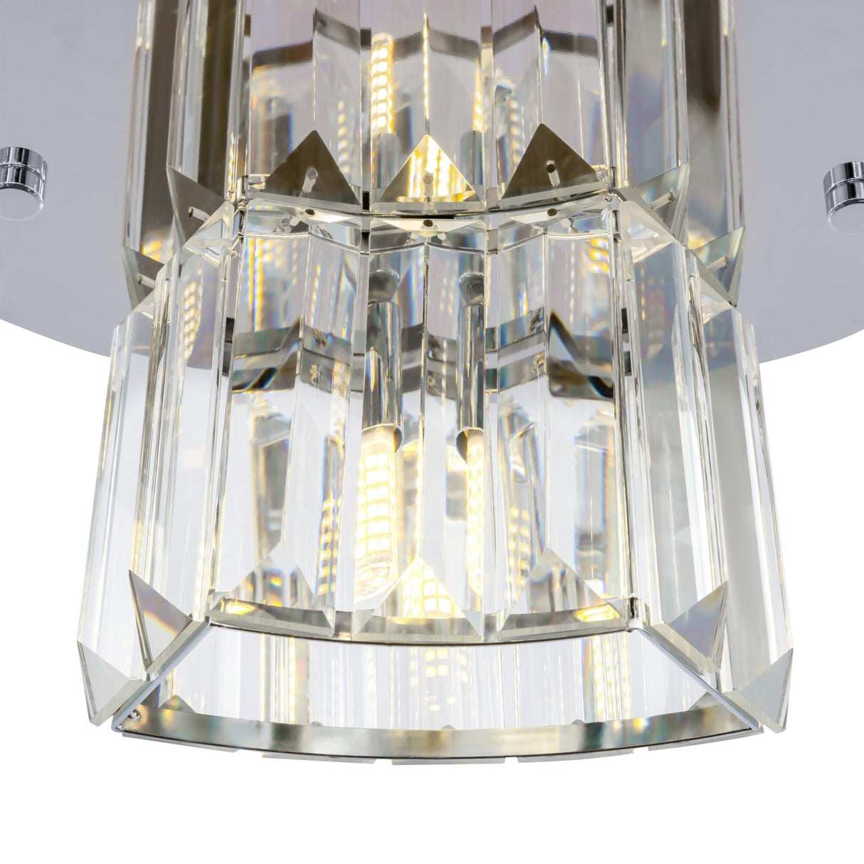 A close-up of the Colline 4 Light Chandelier in chrome shows its geometric clear crystal prisms and glass pendants. Warm LED lights shine through the crystals, creating a sparkling effect, showcasing modern lighting elegance.