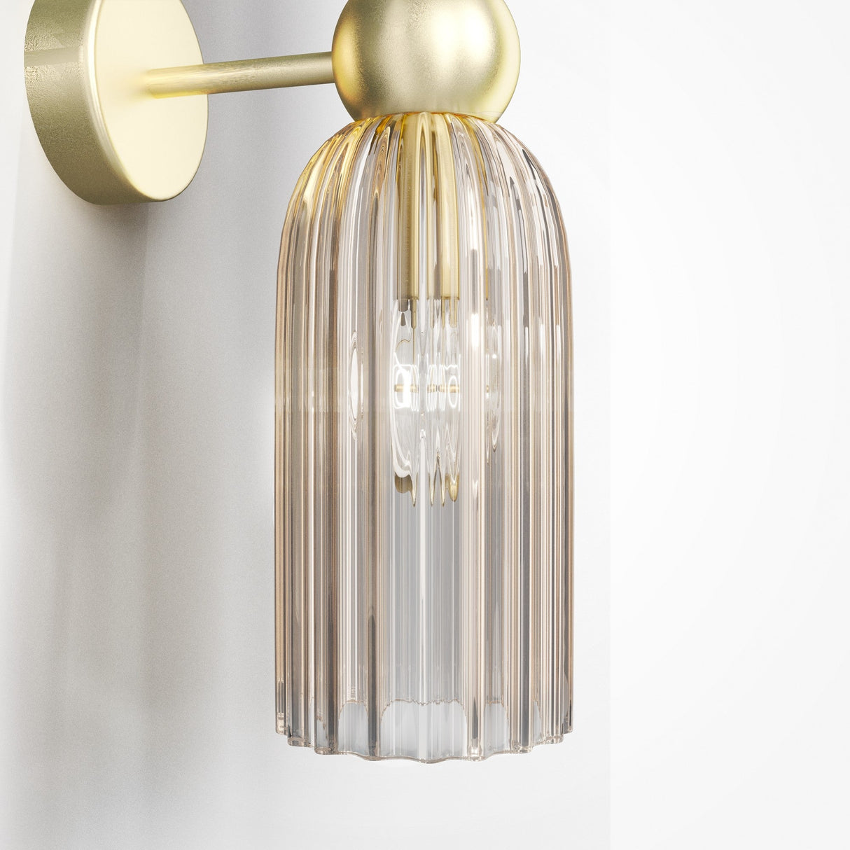 The Antic 2 Light Wall Light features a retro brass finish with a ridged cognac glass shade. The visible bulb shines through clear vertical lines, and the gold wall light mounts on a simple circular base for an elegant look.