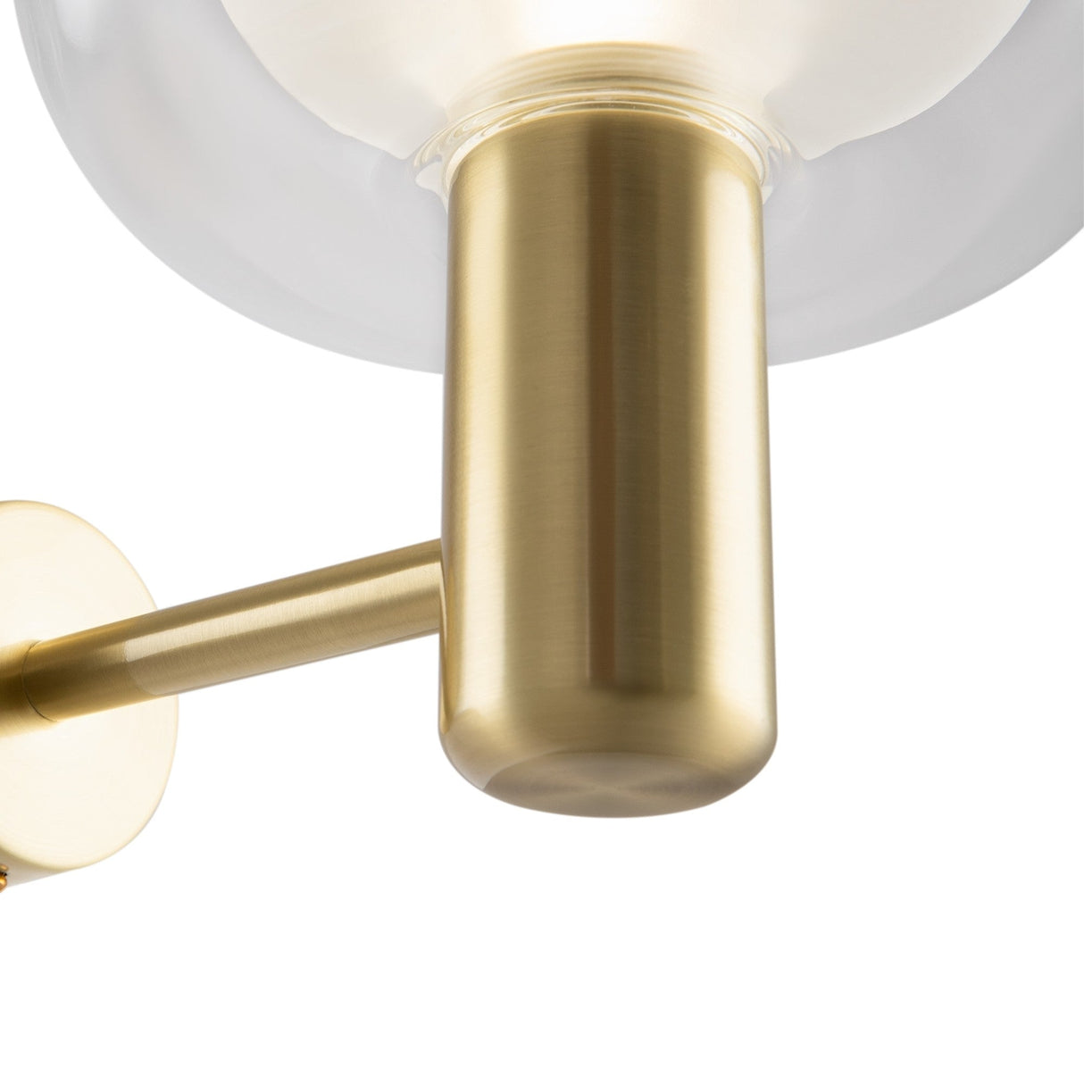 Close-up of the Vision Wall Light, featuring a cylindrical brushed gold arm and fixture with a large clear globe shade. Its minimalist design exudes an elegant Italian neoclassical style.