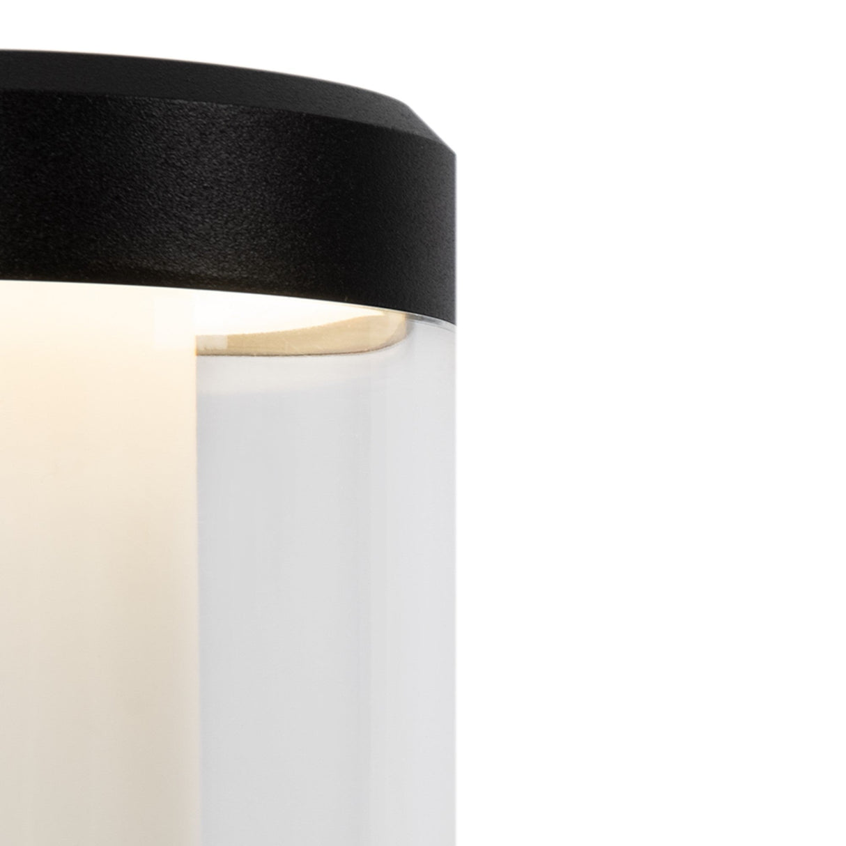 Close-up of a Koln Outdoor LED Wall Light - Black, highlighting its modern cylindrical design with a glossy white body and black top. It illuminates softly from within its corrosion-resistant fixture against a plain white background.