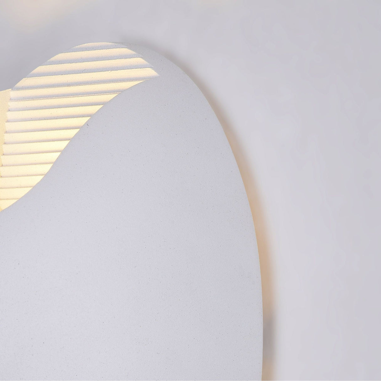 Introducing the Times Square Outdoor Wall Light 3000K 6W - White: a corrosion-resistant fixture with a smooth, curved exterior and ridged, glowing section. Its sleek white design contrasts with textured illuminated lines for energy-efficient lighting that enhances modern facades.