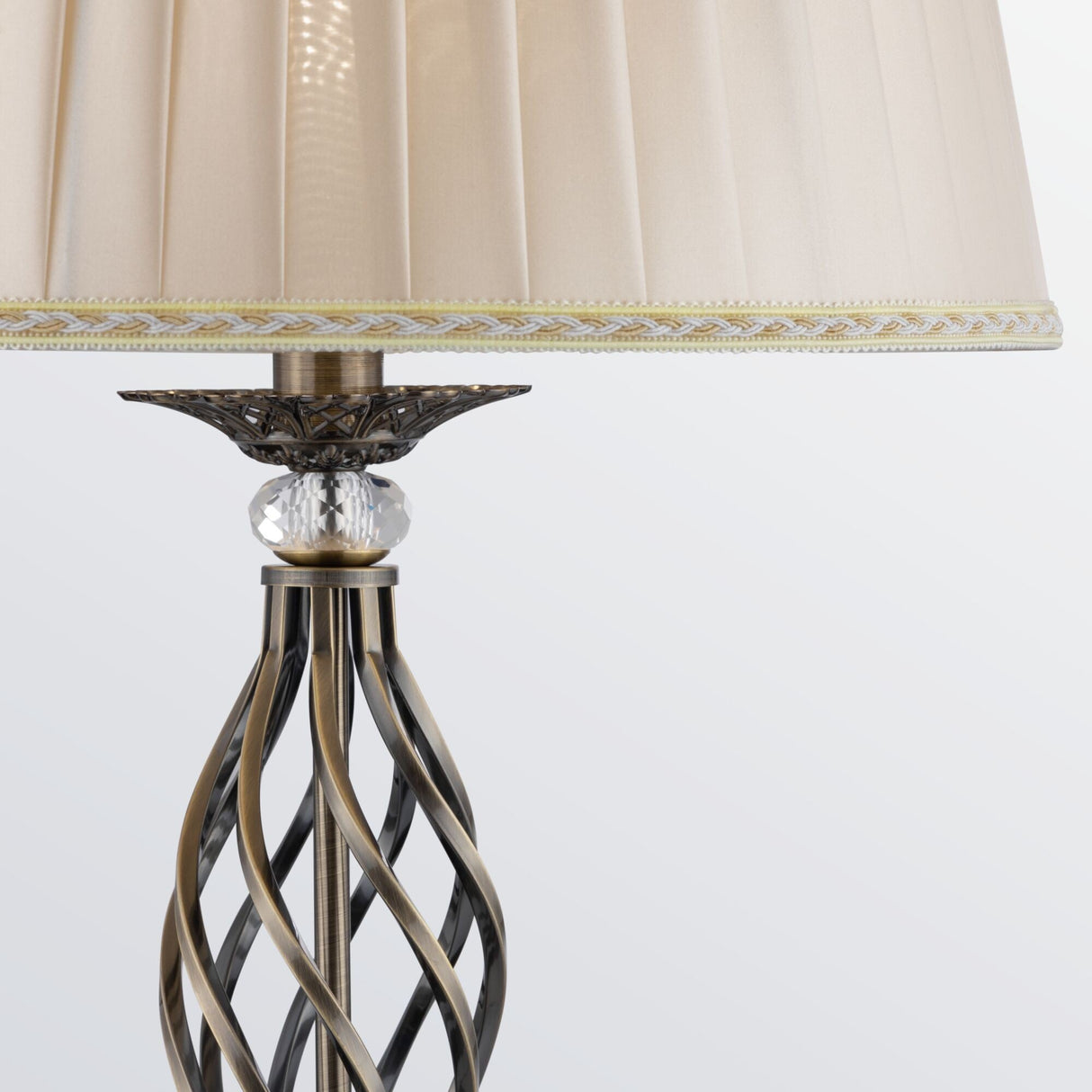 Close-up of the Grace Floor Lamp - Bronze with a twisted metallic base in bronze finish and crystal accents. It features a cream lampshade with vertical stripes and decorative trim against a light gray background.