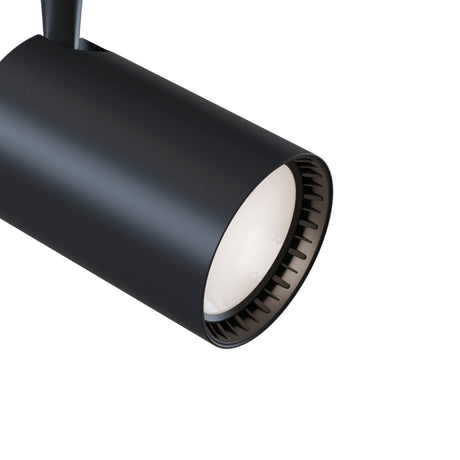 The Vuoro LED Single Phase Unity Track Spotlight 15W 3000K - Black, featuring a slick cylindrical design, is highlighted against a white backdrop. This energy-efficient spotlight faces downward, revealing part of its inner lining for ideal accent lighting.