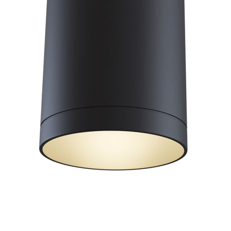 Heres a close-up view of the Single Phase UNITY Track Pendant Light in black, featuring a sleek cylindrical design with a smooth finish, exuding a warm, soft glow like that of a modern industrial light.