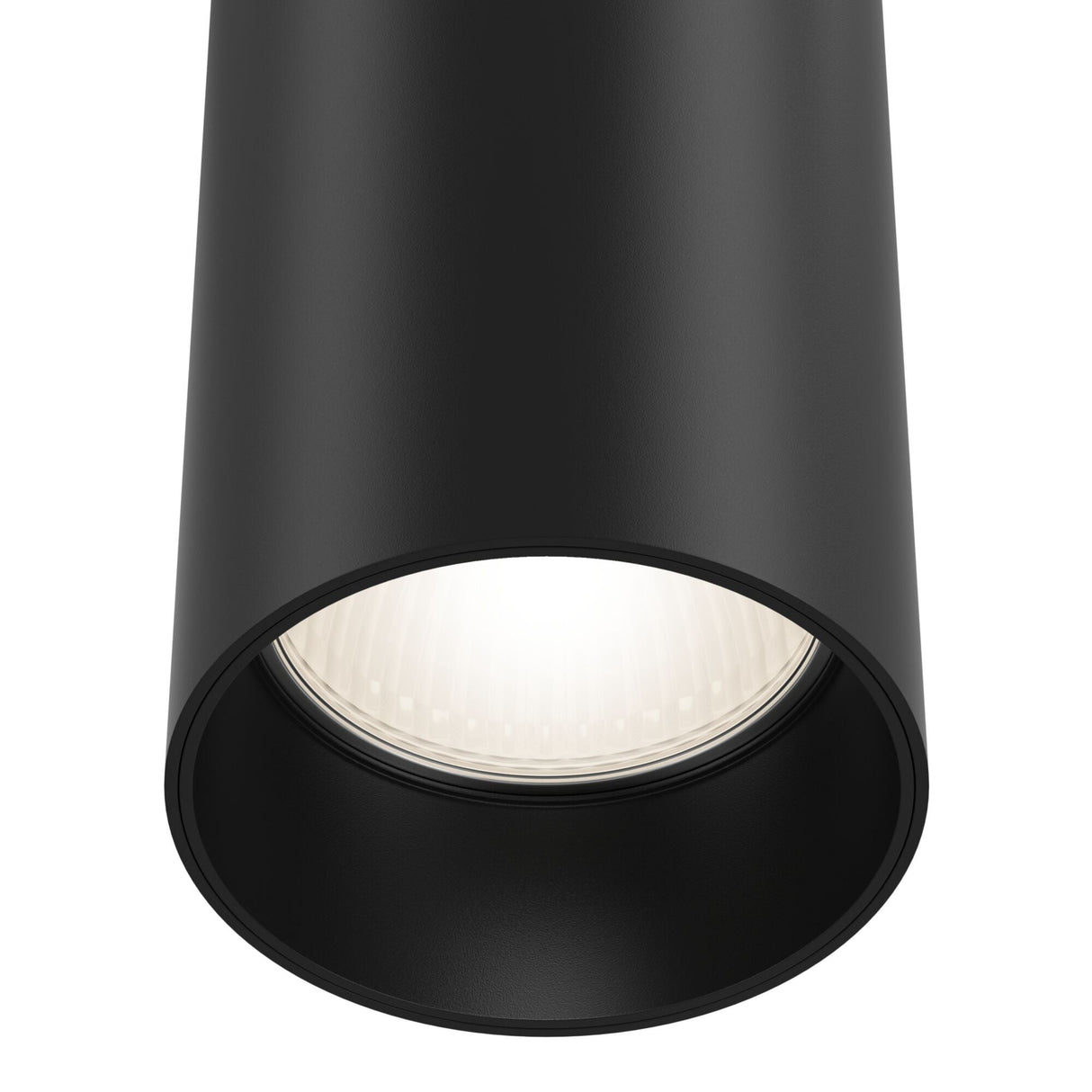 The close-up of the Focus Single Phase UNITY Track Pendant Light - Black reveals a glowing bulb inside. Emitting bright white light, it highlights the smooth matte finish of the industrial design black cylindrical ceiling light.