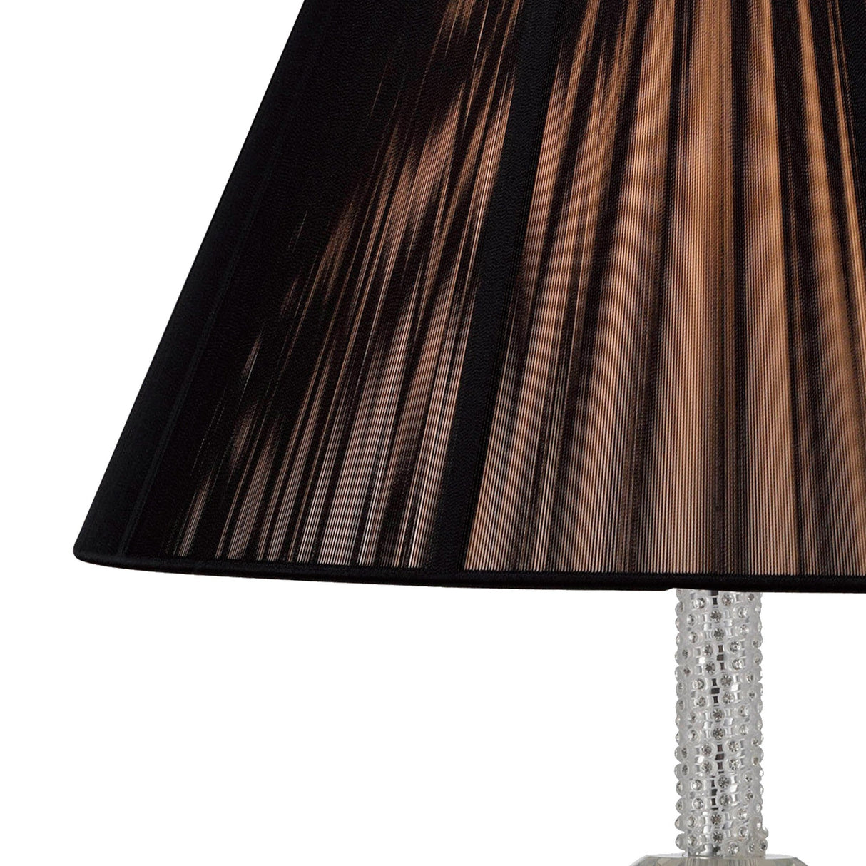 Close-up of the Elena 1 Light Crystal Table Lamp—Chrome (Without Shade), featuring a textured crystal base beneath a vertically pleated black shade. Light filters through, casting a soft, warm glow that highlights modern craftsmanship.