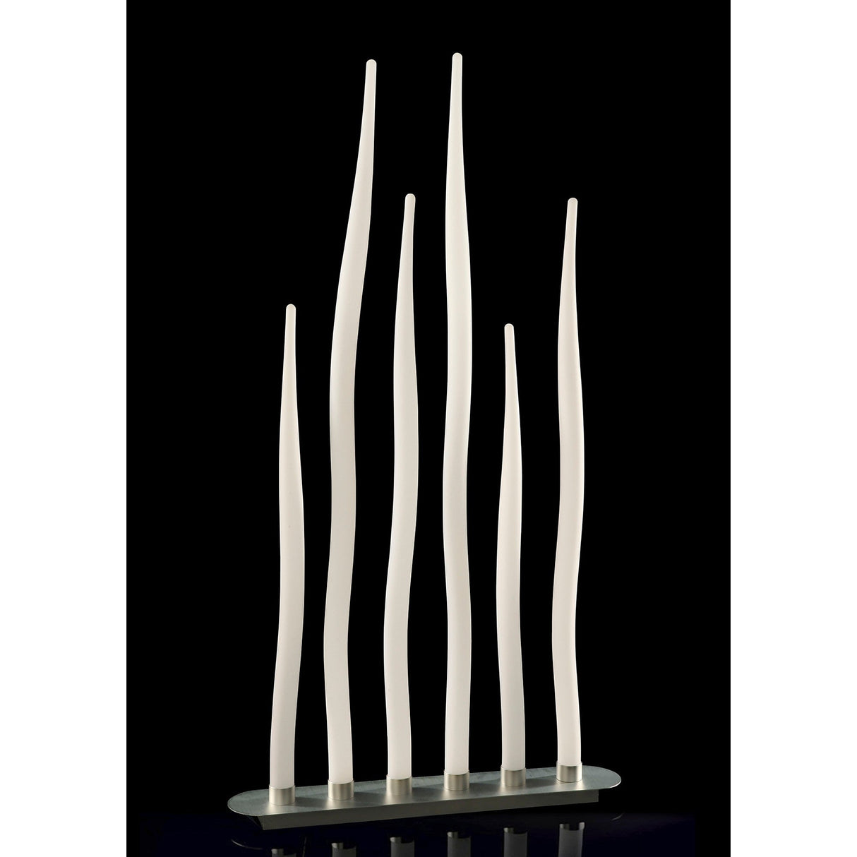 Six tall, slender rods in silver and opal white form the Estalacta 6 Light Outdoor Floor Lamp, standing gracefully on an oval base against a black backdrop, showcasing elegant contemporary outdoor lighting design.