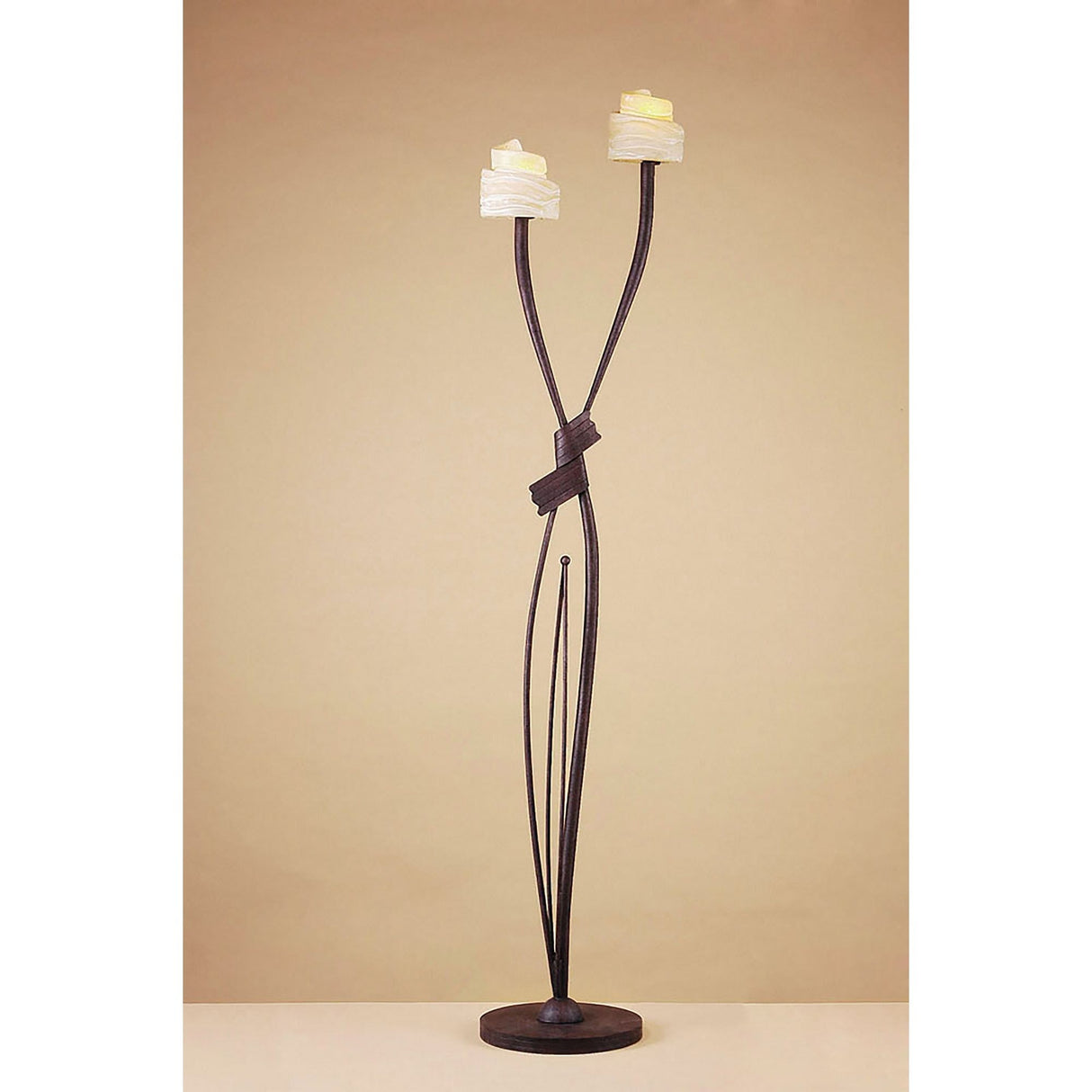 The Estilo 2 Light Floor Lamp in Brown & Black Oxide features two upward-curving arms with amber frosted glass candle-shaped shades on a dark metal frame, offering ambient lighting against a beige background.