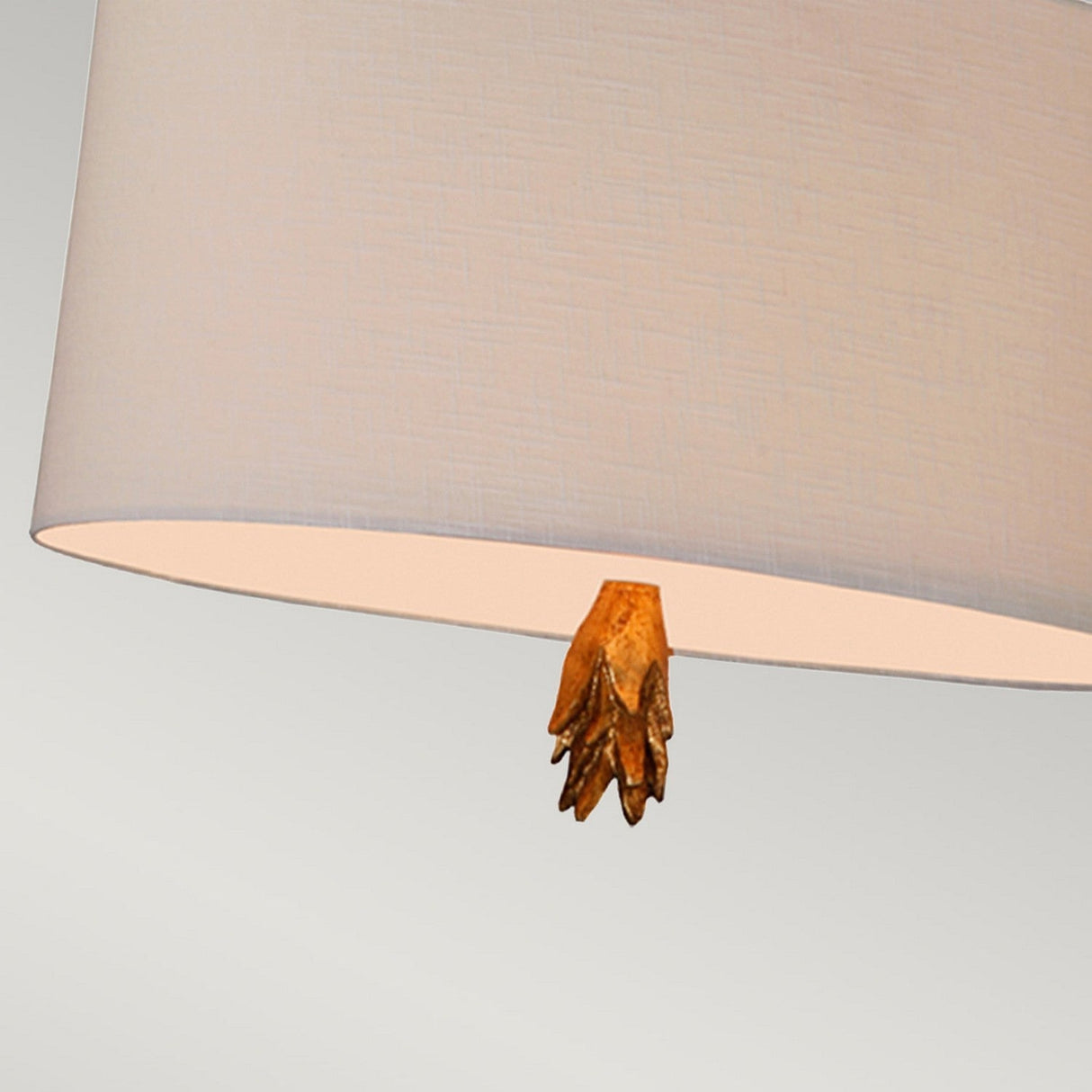 Close-up of the Flambeau 2 Light Pendant, showcasing its distinctive design. The pendant's lampshade includes a decorative element that resembles a small wooden hand or claw. Its detailed texture is accentuated against a neutral, light gray background, complementing modern interior styles effortlessly.