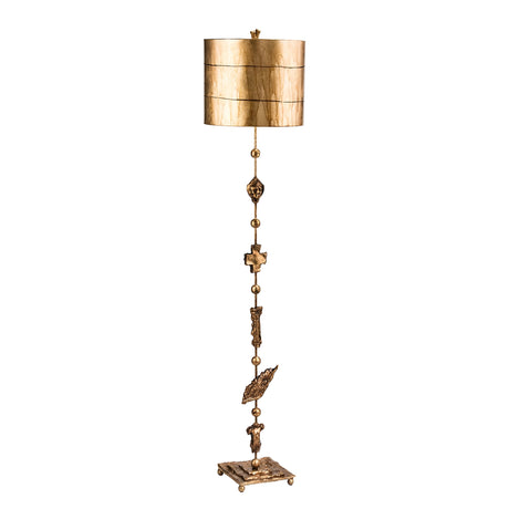 The Fragment 1 Light Floor Lamp in Aged Gold features a tall and ornate design with intricate embellishments along its stand. It is topped with a golden cylindrical lampshade and incorporates decorative details on the square base, enhancing its luxurious appeal while providing ambient lighting to any space.