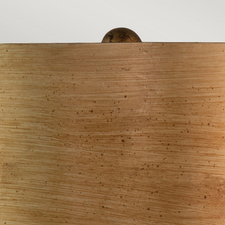 The Jackson 1 Light Table Lamp in Antiqued Silver with Gold Leaf is showcased against a wooden surface featuring smooth textures and natural grain patterns that evoke warmth. Atop this elegant display, the lamp's antiqued silver finish provides a sophisticated touch, enhancing the understated charm of the scene.